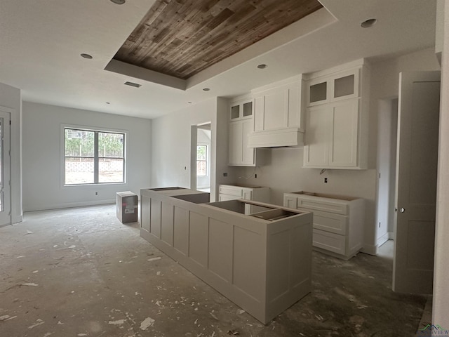 kitchen with a tray ceiling, white cabinetry, and a center island