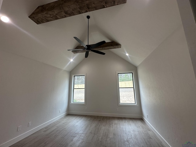 spare room featuring lofted ceiling, a ceiling fan, light wood-style flooring, and baseboards