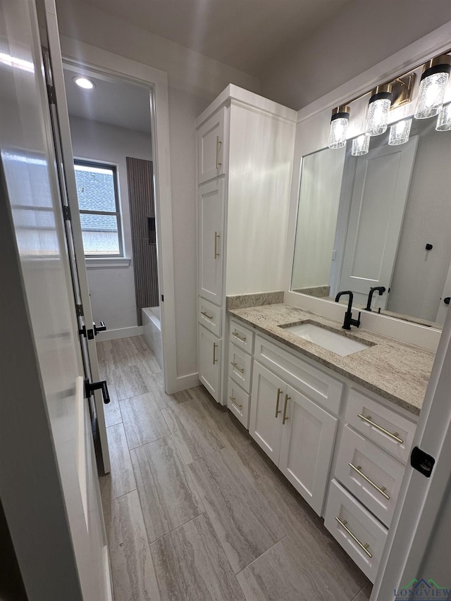 bathroom with shower / bathing tub combination, vanity, and baseboards