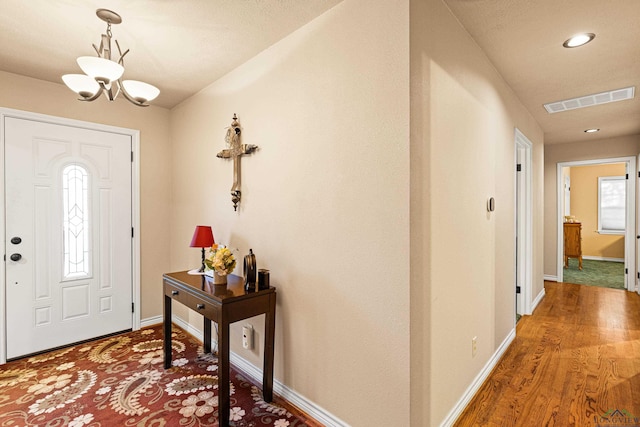 entryway with a chandelier and wood-type flooring