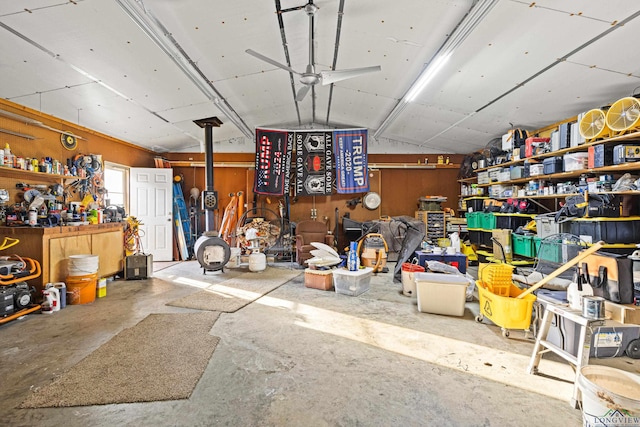 misc room with lofted ceiling, a workshop area, concrete floors, and wooden walls