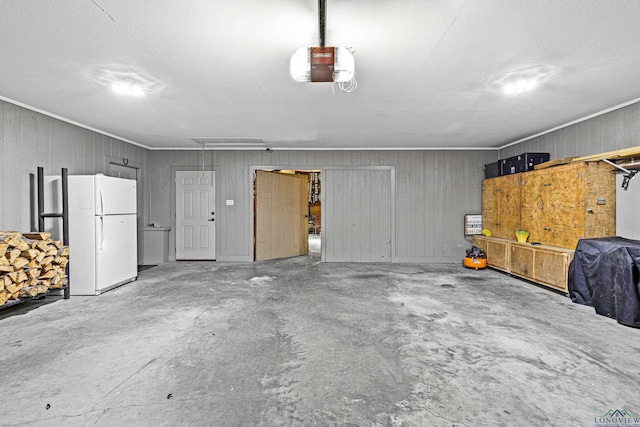 garage featuring white fridge and a garage door opener