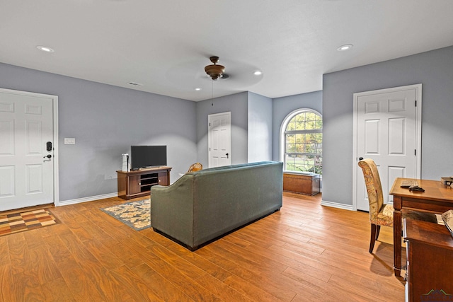 living room with light hardwood / wood-style flooring and ceiling fan