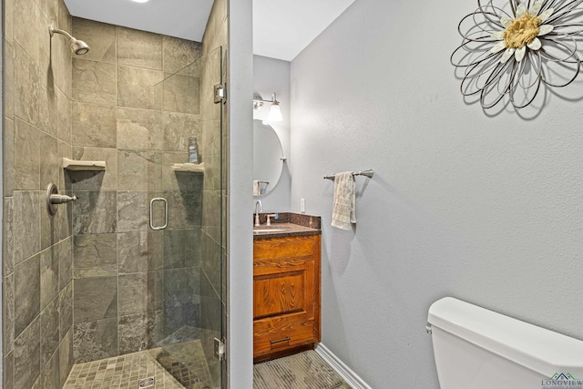 bathroom featuring vanity, toilet, and a shower with door