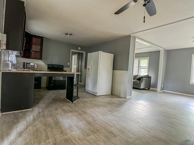 kitchen featuring black range with electric stovetop, ceiling fan, white fridge with ice dispenser, kitchen peninsula, and light hardwood / wood-style floors