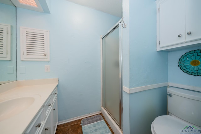 bathroom with vanity, toilet, and a shower with door