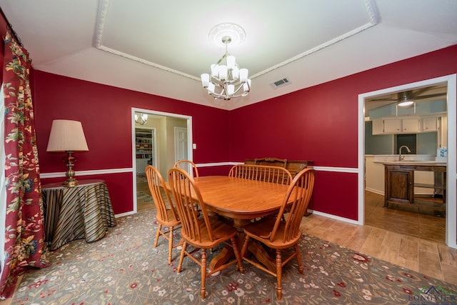 dining room with a chandelier, hardwood / wood-style floors, and sink