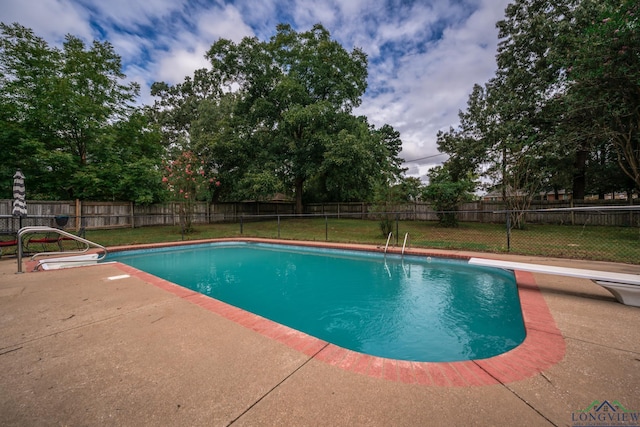 view of pool featuring a yard, a diving board, and a patio area