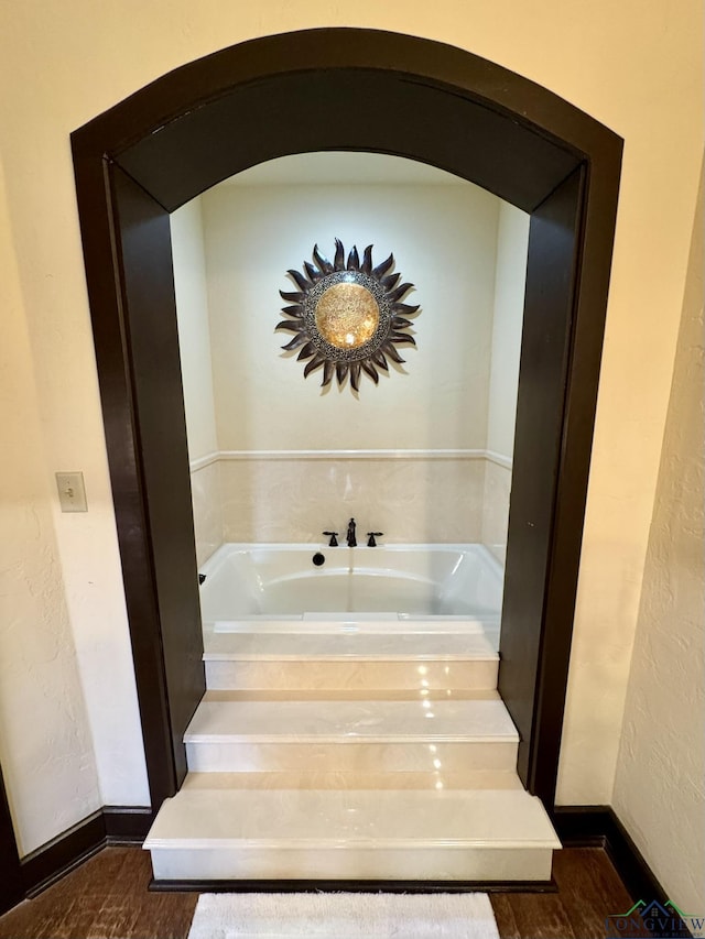 bathroom with hardwood / wood-style floors and a washtub