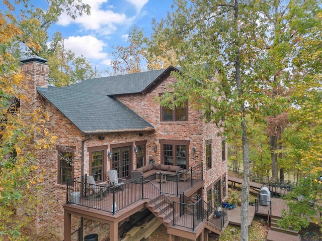 rear view of property featuring a wooden deck and outdoor lounge area