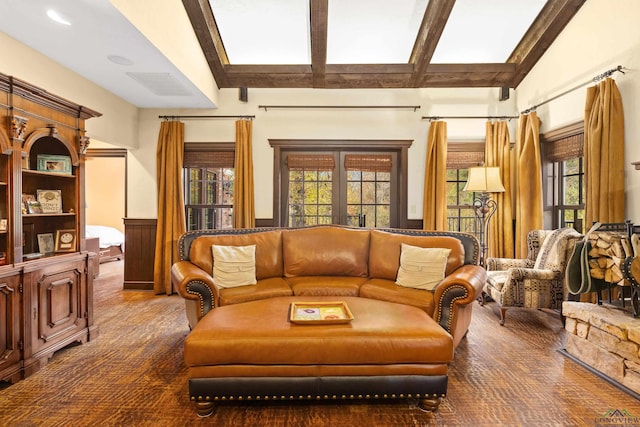 sitting room featuring french doors and lofted ceiling with beams