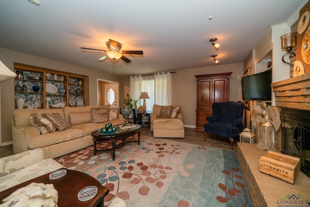 living room featuring a fireplace, light wood-type flooring, and ceiling fan