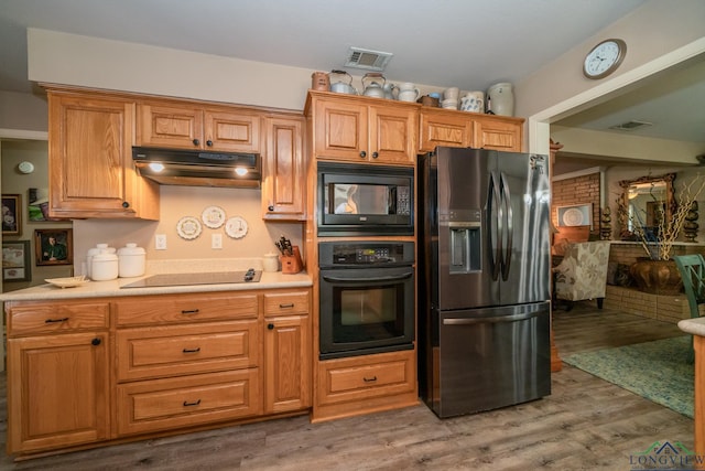 kitchen with hardwood / wood-style floors and black appliances