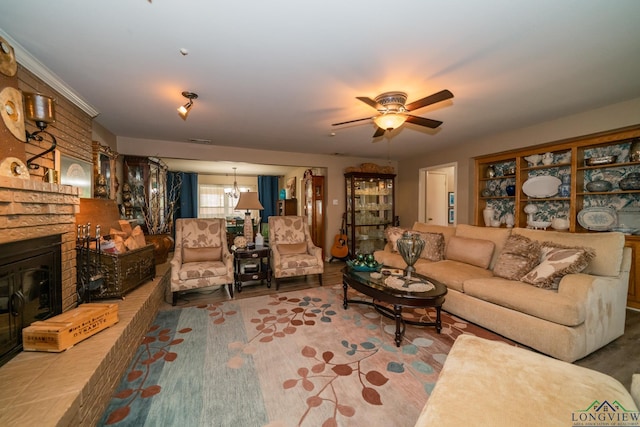 living room with a fireplace and ceiling fan with notable chandelier