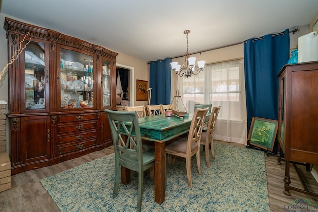 dining room with wood-type flooring and a notable chandelier