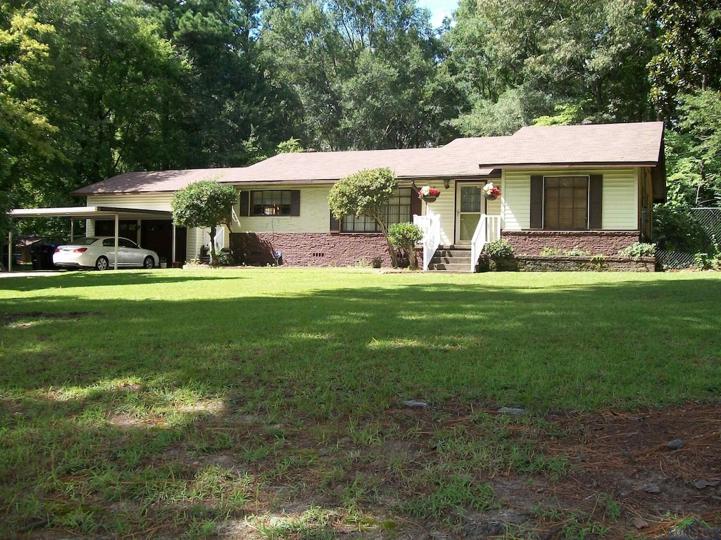 ranch-style house featuring a front yard and a carport