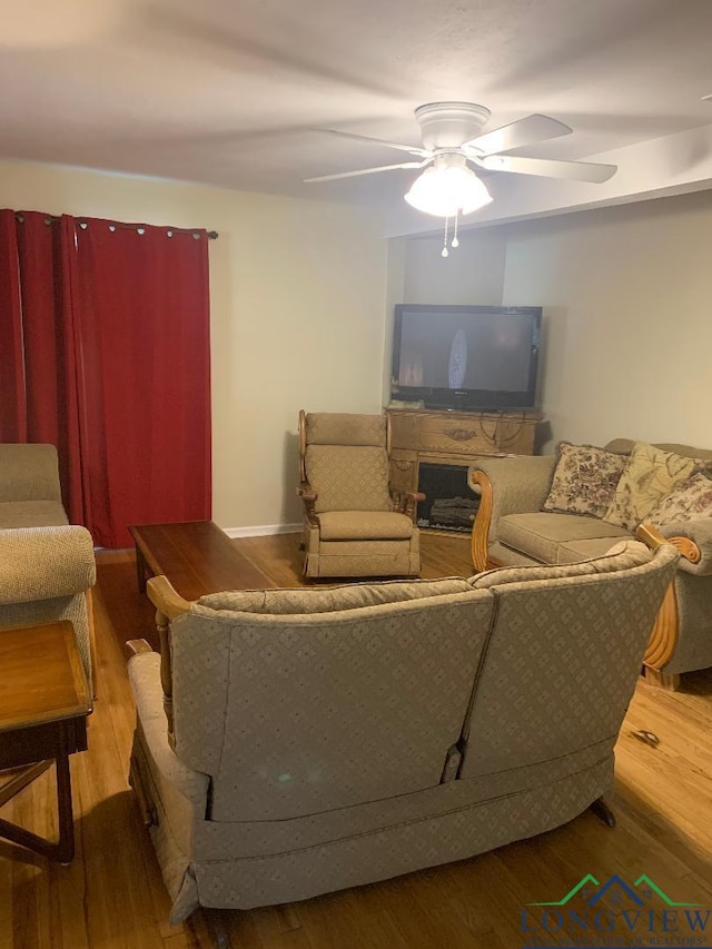 living room featuring ceiling fan and wood-type flooring