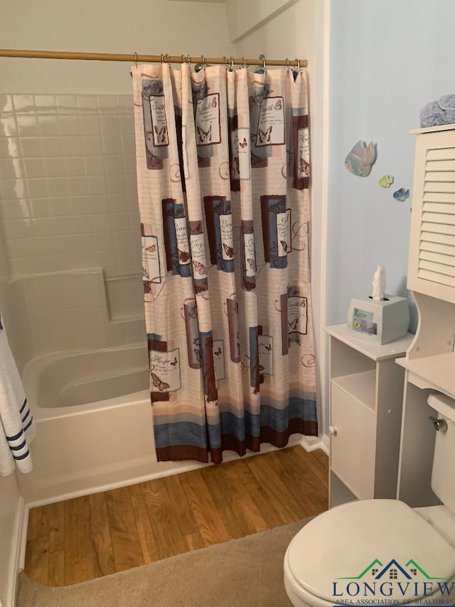 bathroom featuring shower / bath combo with shower curtain, wood-type flooring, and toilet