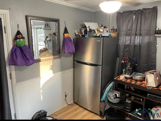 kitchen featuring light hardwood / wood-style flooring, stainless steel refrigerator, and ornamental molding