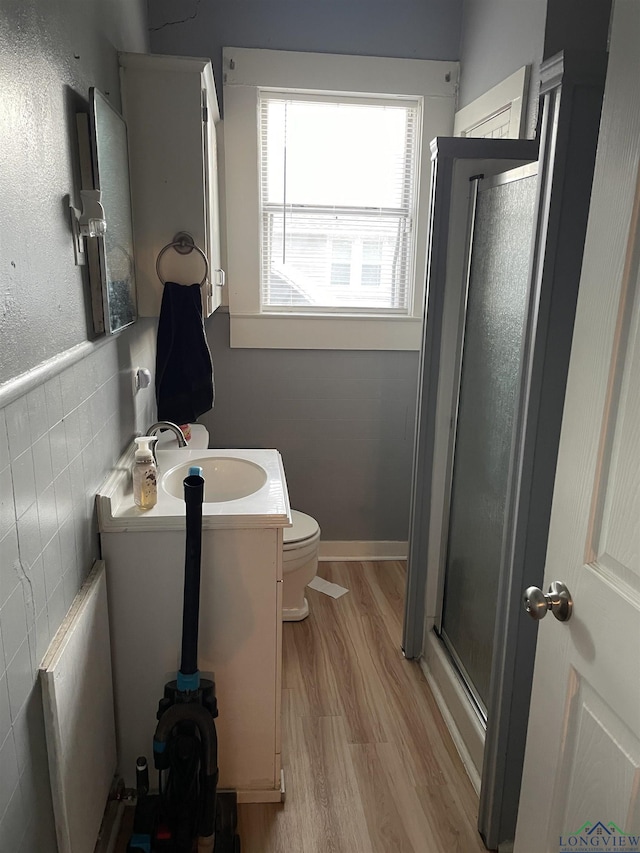 bathroom featuring hardwood / wood-style flooring, vanity, toilet, and an enclosed shower