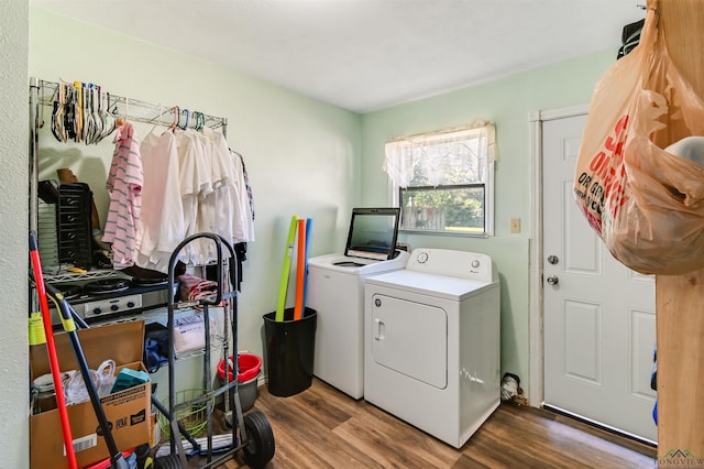 clothes washing area with washing machine and clothes dryer and wood-type flooring