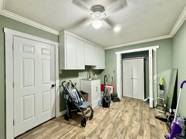 2305 Buccaneer Dr, Longview, TX 75604 - washroom with a textured ceiling, light wood finished floors, a ceiling fan, crown molding, and a sink