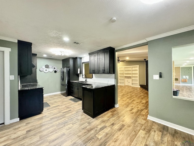 2305 Buccaneer Dr, Longview, TX 75604 - kitchen featuring fridge with ice dispenser, a sink, ceiling fan, a textured ceiling, and light wood finished floors