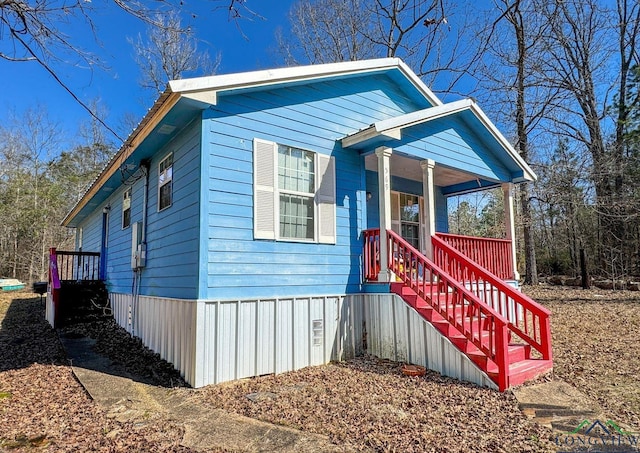 view of front of property with covered porch and stairway