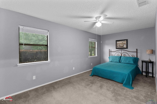 bedroom with a textured ceiling, carpet flooring, baseboards, and ceiling fan