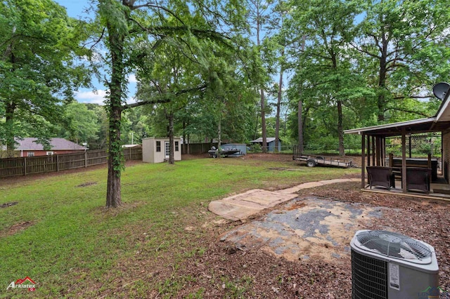 view of yard with central air condition unit, a storage unit, an outdoor structure, and view of scattered trees