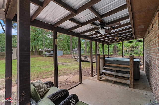 view of patio / terrace featuring a hot tub, an outbuilding, a storage shed, and a ceiling fan
