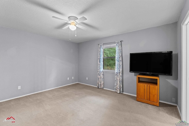 unfurnished living room featuring ceiling fan, light carpet, baseboards, and a textured ceiling