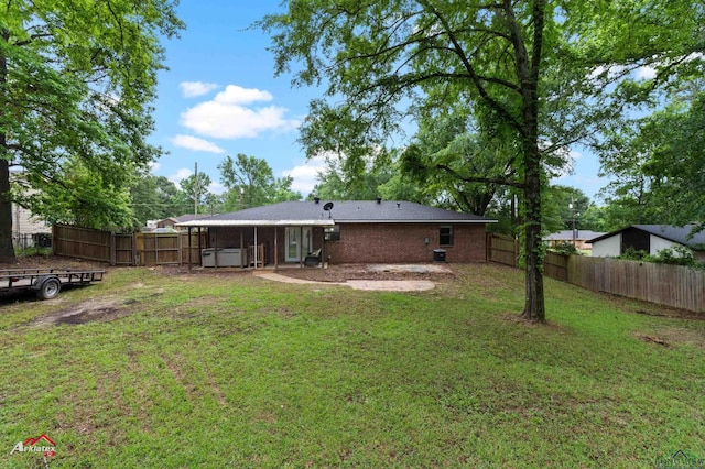 rear view of property with a patio area and a jacuzzi