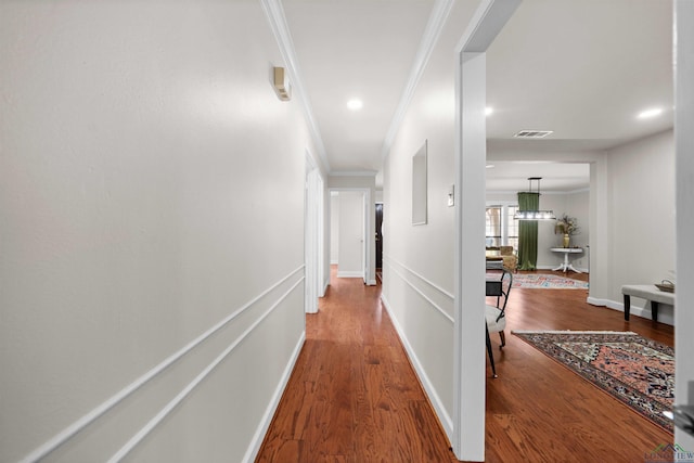 hall with wood-type flooring and crown molding