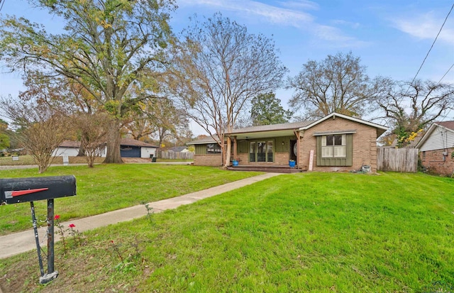 ranch-style house featuring covered porch and a front yard