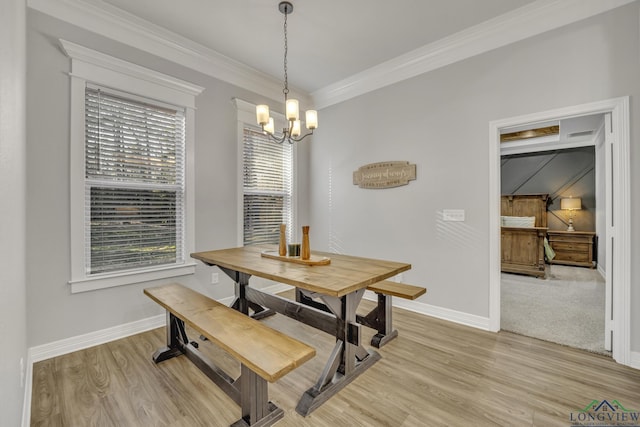 dining space featuring an inviting chandelier, ornamental molding, and light hardwood / wood-style floors