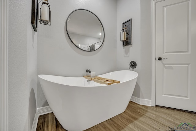 bathroom with wood-type flooring and a bathing tub