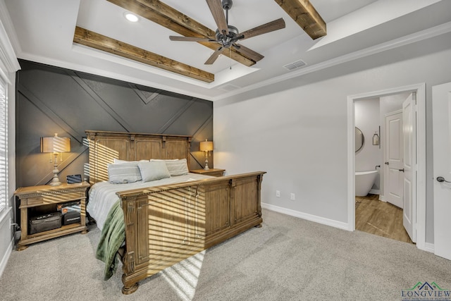 bedroom featuring connected bathroom, a raised ceiling, light colored carpet, ceiling fan, and ornamental molding