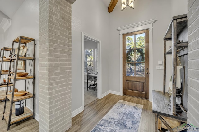 foyer entrance featuring high vaulted ceiling, beam ceiling, and light hardwood / wood-style floors