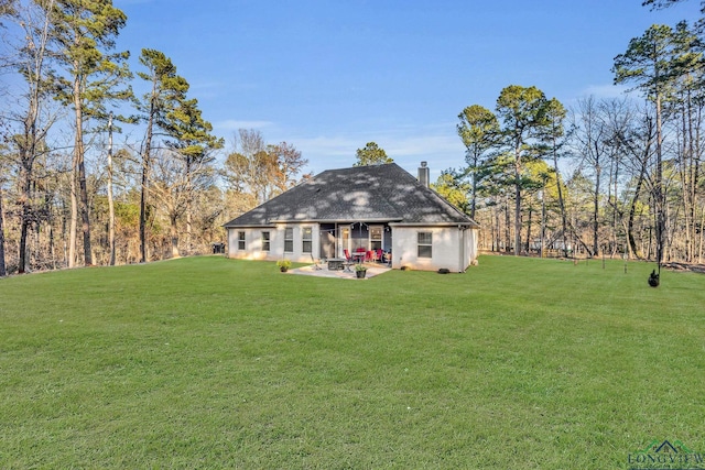 back of house with a lawn and a patio