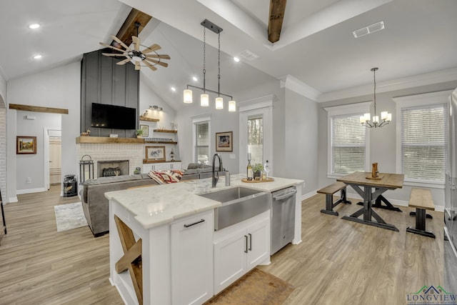 kitchen featuring stainless steel dishwasher, hanging light fixtures, a kitchen island with sink, white cabinets, and sink