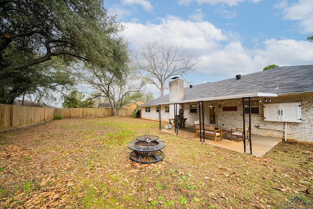 view of yard featuring an outdoor fire pit and a patio area