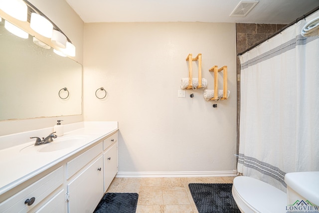 bathroom featuring tile patterned flooring, vanity, and toilet