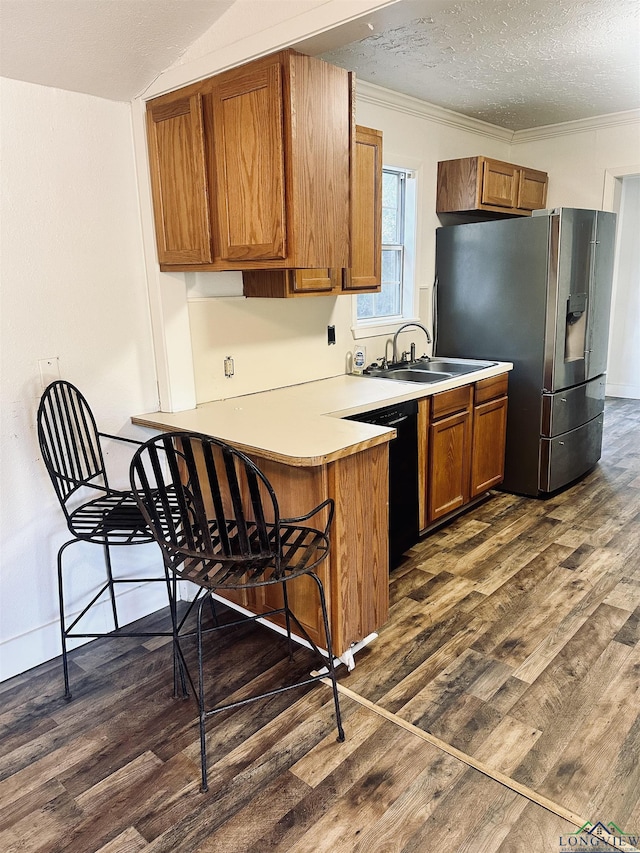 kitchen featuring dishwasher, sink, stainless steel refrigerator with ice dispenser, ornamental molding, and a textured ceiling