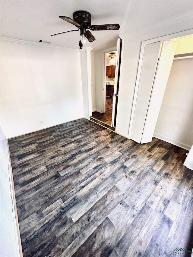 unfurnished bedroom featuring dark hardwood / wood-style flooring, ceiling fan, and ornamental molding