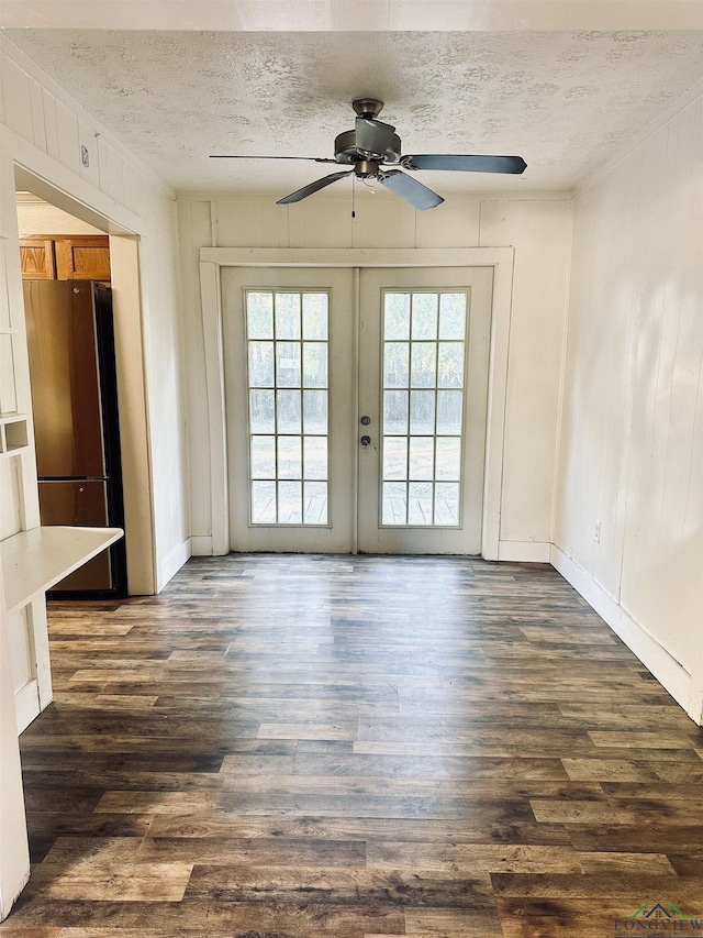 empty room with french doors, a textured ceiling, dark hardwood / wood-style floors, and ceiling fan