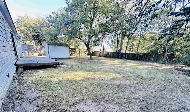 view of yard with a deck and a storage shed