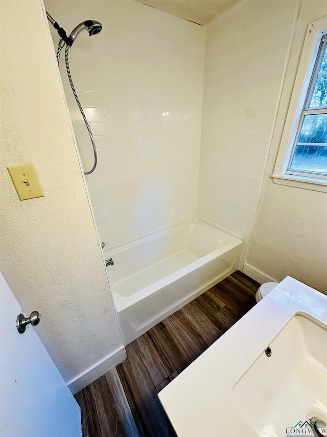 bathroom with  shower combination, wood-type flooring, and sink