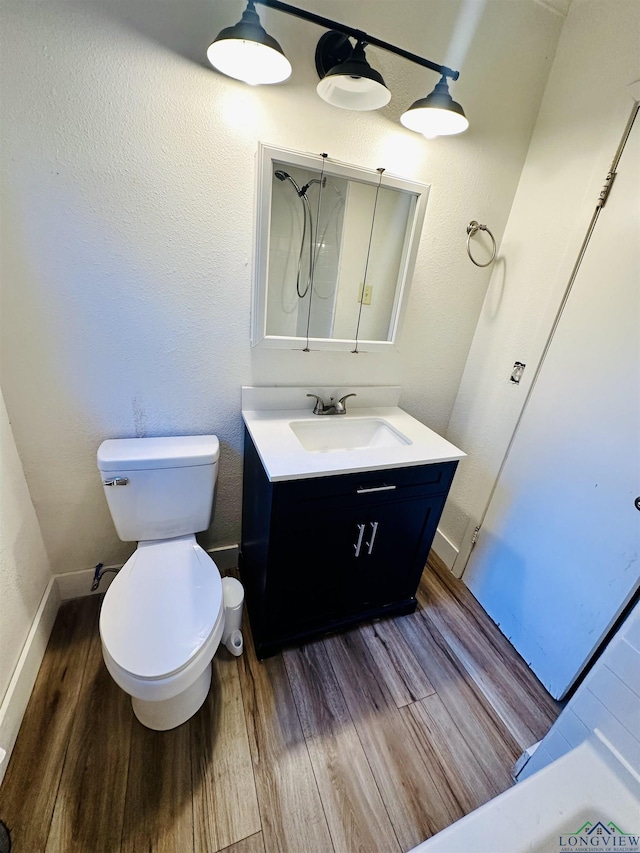 bathroom with wood-type flooring, vanity, and toilet