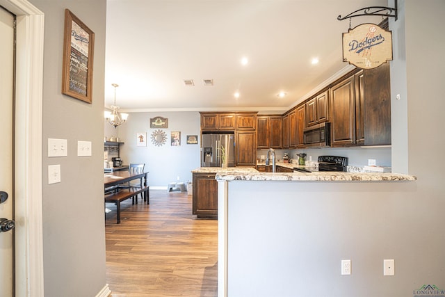 kitchen with kitchen peninsula, appliances with stainless steel finishes, light stone countertops, crown molding, and light hardwood / wood-style flooring